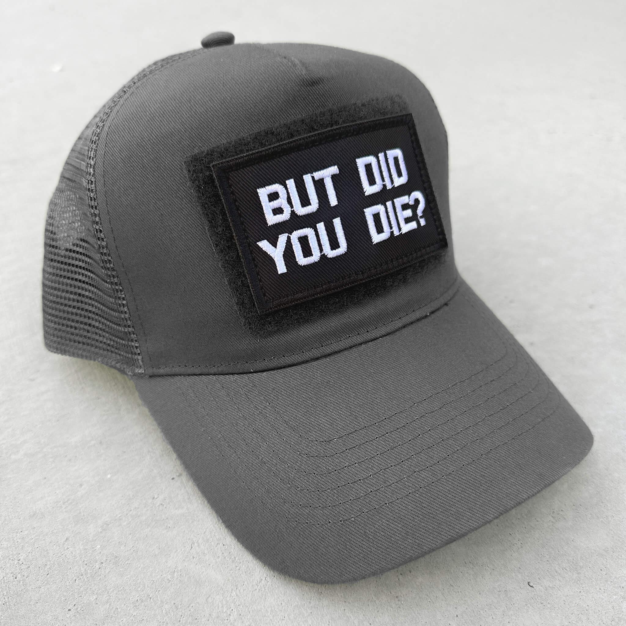The trucker snapback cap in grey with But Did You Die patch attached